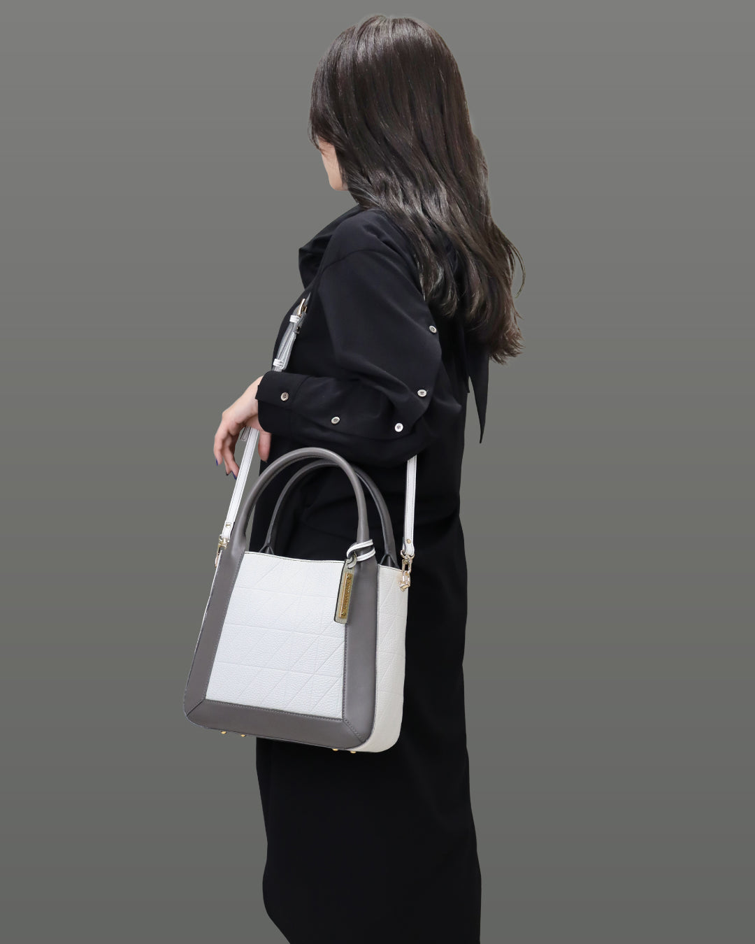 女性がホワイト色のバッグを左肩に掛けている画像。